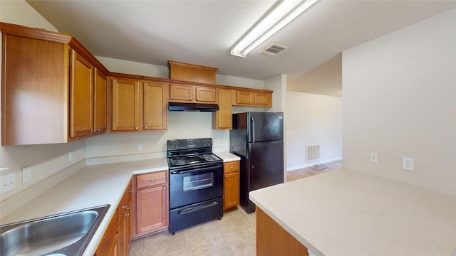 25531 Black St, Splendora, TX 77372 - kitchen with black appliances, under cabinet range hood, brown cabinetry, and light countertops