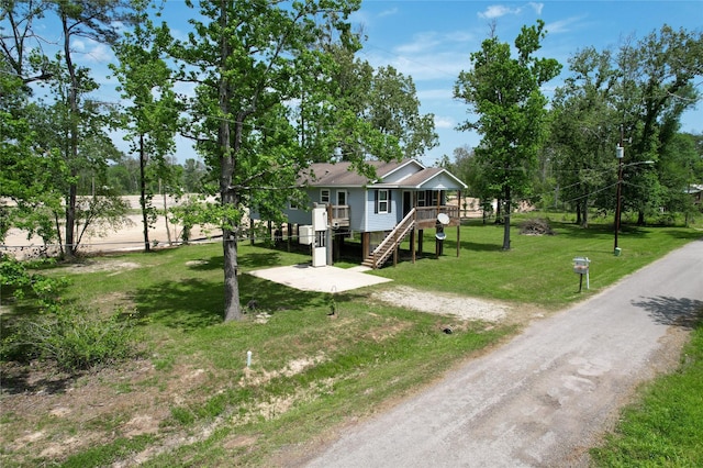 25531 Black St, Splendora, TX 77372 - raised beach house with stairway, dirt driveway, and a front yard