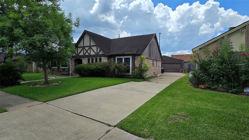 4531 Hickory Downs Dr, Houston, TX 77084 - tudor home with a front lawn, brick siding, and a detached garage