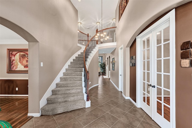 5806 Wilton St, Pearland, TX 77584 - foyer featuring french doors, arched walkways, stairway, dark tile patterned flooring, and crown molding