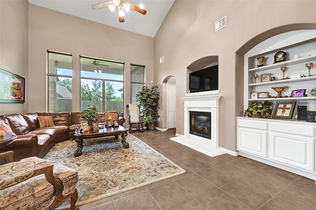 5806 Wilton St, Pearland, TX 77584 - living area with a ceiling fan, high vaulted ceiling, a glass covered fireplace, dark tile patterned floors, and built in features