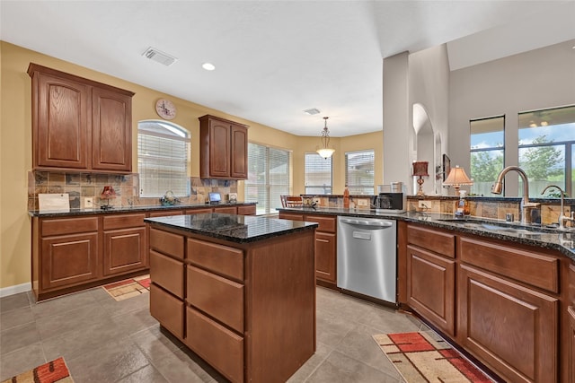 5806 Wilton St, Pearland, TX 77584 - kitchen featuring dishwasher, backsplash, dark stone counters, a kitchen island, and pendant lighting