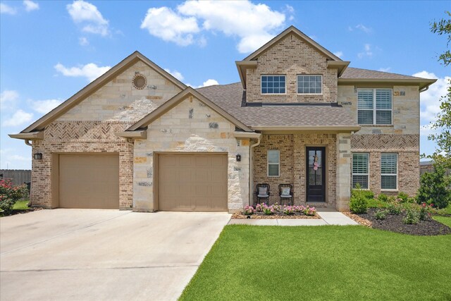 508 Buckhorn St, Sealy, TX 77474 - view of front of home with driveway, a front yard, a garage, a shingled roof, and stone siding