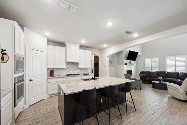 508 Buckhorn St, Sealy, TX 77474 - kitchen featuring appliances with stainless steel finishes, light wood-style floors, a breakfast bar, a center island with sink, and open floor plan