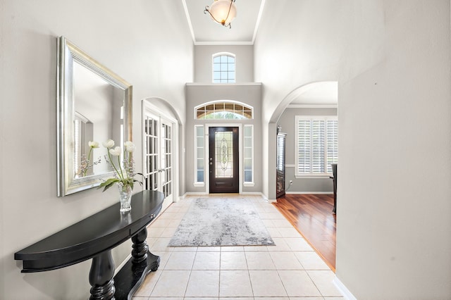 12815 Mimosa Spring Dr, Tomball, TX 77377 - entrance foyer with crown molding, tile patterned floors, arched walkways, and a towering ceiling