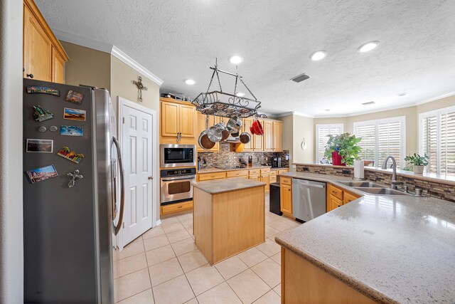 12815 Mimosa Spring Dr, Tomball, TX 77377 - kitchen featuring stainless steel appliances, ornamental molding, a center island, backsplash, and light tile patterned floors