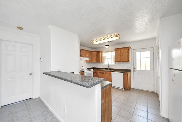 1214 Robert St, Baytown, TX 77521 - kitchen with white appliances, under cabinet range hood, a peninsula, dark countertops, and a textured ceiling