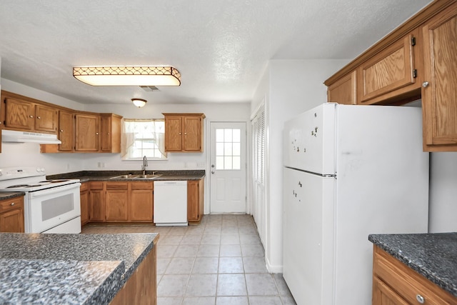1214 Robert St, Baytown, TX 77521 - kitchen with white appliances, brown cabinetry, under cabinet range hood, light tile patterned floors, and a textured ceiling