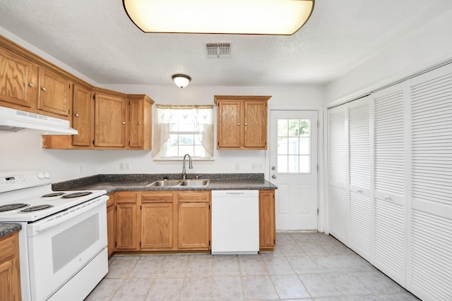1214 Robert St, Baytown, TX 77521 - kitchen featuring white appliances, under cabinet range hood, dark countertops, and brown cabinets