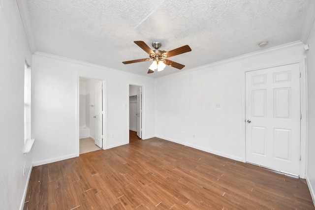 1214 Robert St, Baytown, TX 77521 - unfurnished bedroom with wood finished floors, crown molding, a textured ceiling, a closet, and connected bathroom