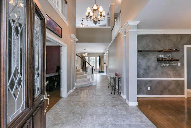 16050 Lockdale Ln, Cypress, TX 77429 - foyer featuring a ceiling fan, stairway, ornamental molding, ornate columns, and a chandelier