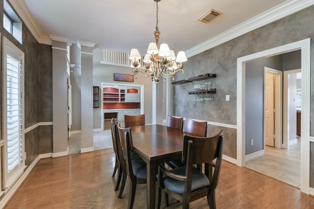 16050 Lockdale Ln, Cypress, TX 77429 - dining area with light wood-type flooring, a chandelier, ornamental molding, and decorative columns