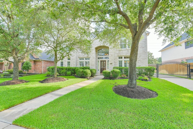 16050 Lockdale Ln, Cypress, TX 77429 - view of front of house with a gate, brick siding, and a front yard