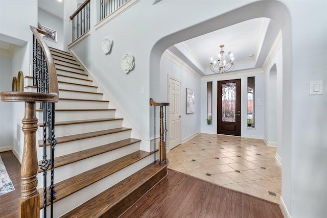 11710 Montmarte Blvd, Houston, TX 77082 - tiled entrance foyer featuring arched walkways, ornamental molding, a chandelier, stairway, and a raised ceiling