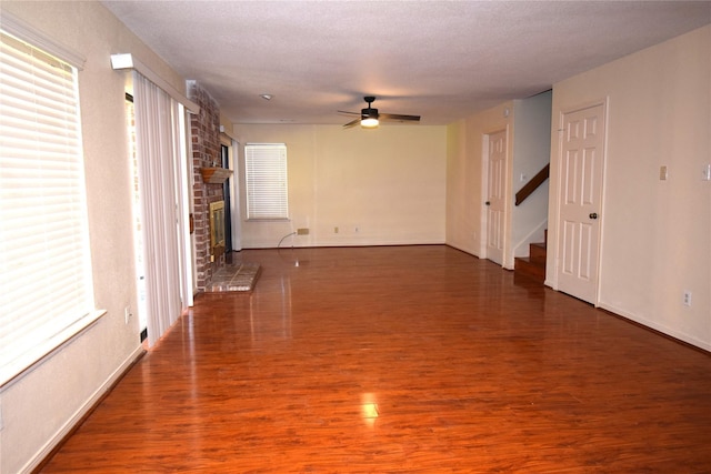 2926 Field Line Dr, Sugar Land, TX 77479 - spare room with stairway, a ceiling fan, wood finished floors, and a brick fireplace