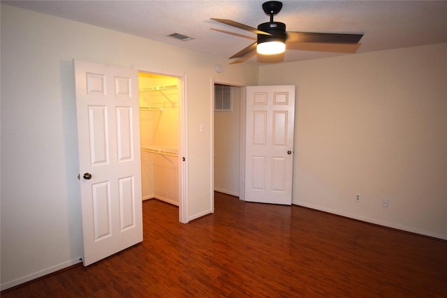 2926 Field Line Dr, Sugar Land, TX 77479 - unfurnished bedroom with a walk in closet, dark wood-style flooring, a closet, and a ceiling fan