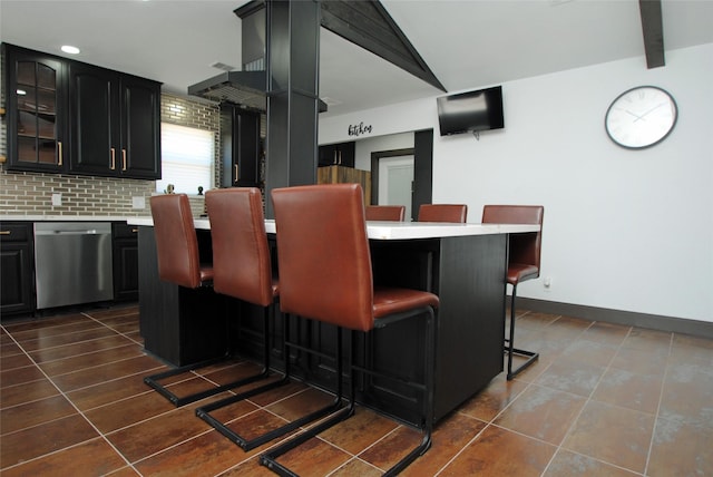 14306 Waterville Way, Houston, TX 77015 - kitchen with stainless steel dishwasher, light countertops, dark cabinets, a kitchen bar, and dark tile patterned flooring