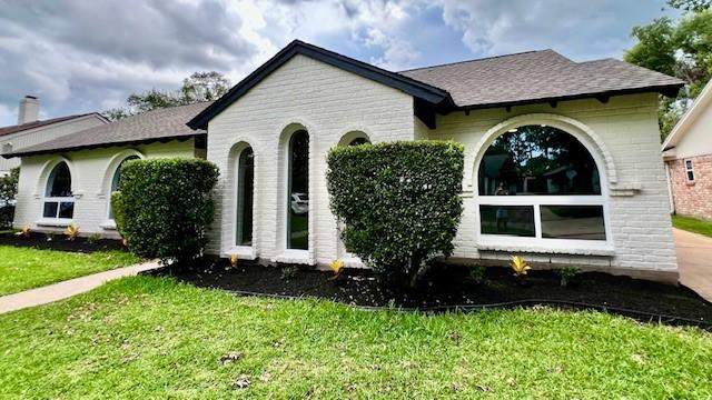 2823 Stetson Ln, Houston, TX 77043 - view of front of home with a front yard, brick siding, and roof with shingles