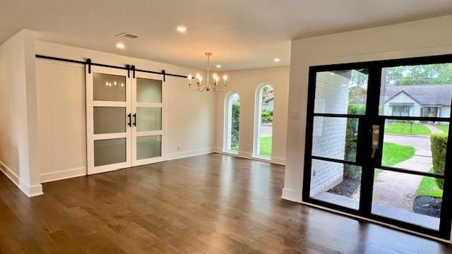 2823 Stetson Ln, Houston, TX 77043 - unfurnished dining area featuring a barn door, plenty of natural light, dark wood-style flooring, and recessed lighting
