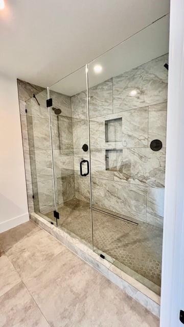 2823 Stetson Ln, Houston, TX 77043 - bathroom featuring a shower stall and baseboards
