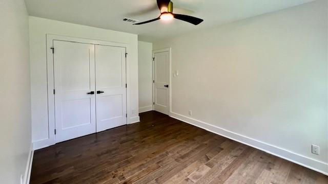 2823 Stetson Ln, Houston, TX 77043 - unfurnished bedroom with dark wood-style flooring, a closet, and a ceiling fan
