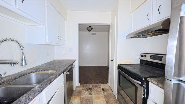 5625 Antoine Dr Unit 606, Houston, TX 77091 - kitchen with appliances with stainless steel finishes, under cabinet range hood, white cabinets, light stone finish flooring, and dark stone counters