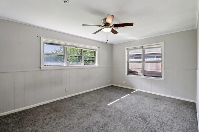 122 22nd Ave N, Texas City, TX 77590 - spare room featuring ceiling fan, a wainscoted wall, carpet flooring, and wood walls