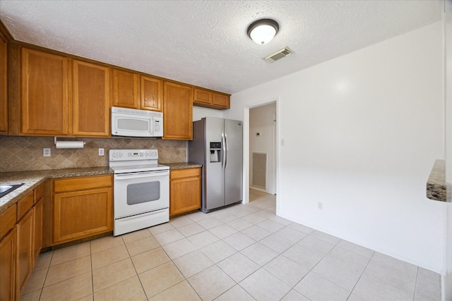11311 Terrebone Dr, Cypress, TX 77429 - kitchen with white appliances, brown cabinetry, backsplash, a textured ceiling, and light tile patterned floors