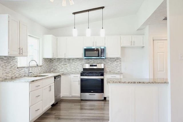 5010 Malmedy Rd, Houston, TX 77033 - kitchen featuring appliances with stainless steel finishes, light stone countertops, white cabinetry, and lofted ceiling