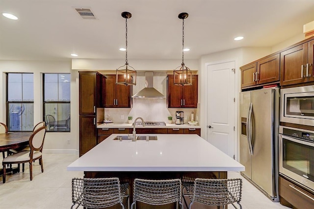 2514 Detering St, Houston, TX 77007 - kitchen featuring stainless steel appliances, wall chimney range hood, light countertops, a center island with sink, and recessed lighting