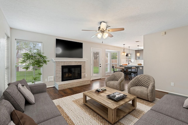 7015 Redwood Falls Dr, Pasadena, TX 77505 - living room with a ceiling fan, wood finished floors, a fireplace, and a textured ceiling