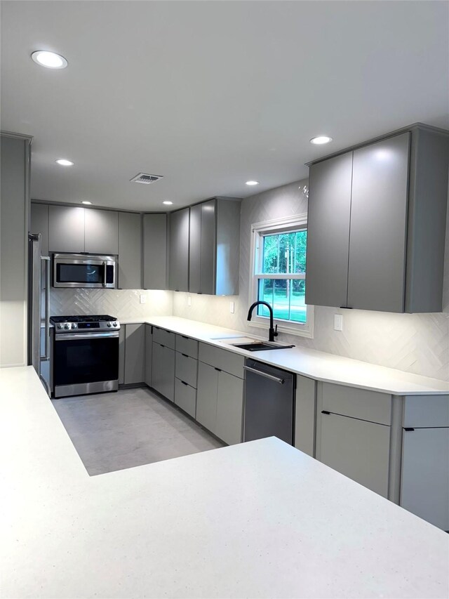 142 Beverly Ln, Bellaire, TX 77401 - kitchen with stainless steel appliances, gray cabinets, tasteful backsplash, light countertops, and recessed lighting