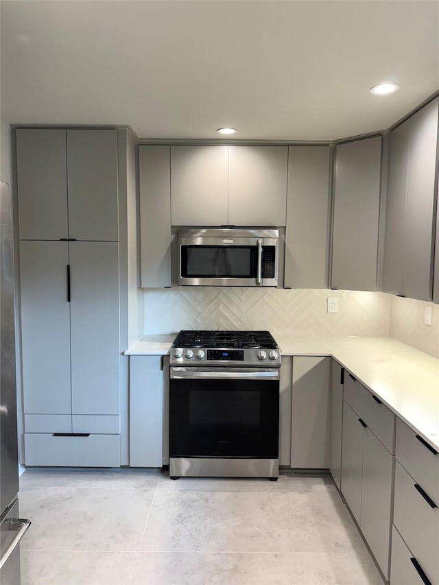 142 Beverly Ln, Bellaire, TX 77401 - kitchen featuring appliances with stainless steel finishes, gray cabinetry, decorative backsplash, light countertops, and recessed lighting