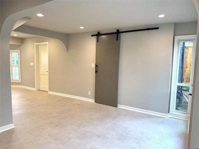142 Beverly Ln, Bellaire, TX 77401 - empty room with a barn door, arched walkways, and recessed lighting