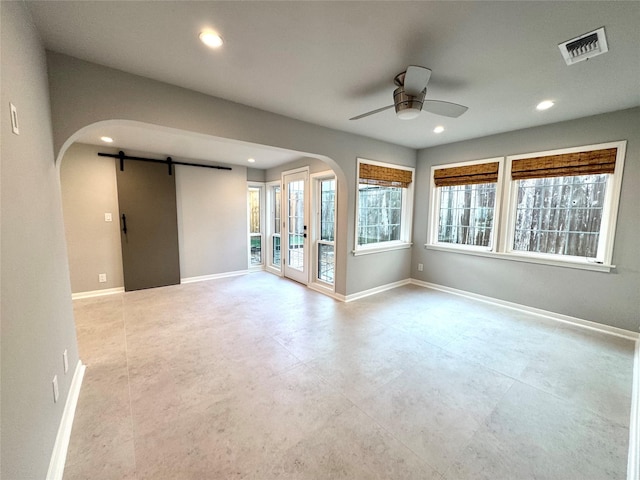 142 Beverly Ln, Bellaire, TX 77401 - unfurnished room with a barn door, arched walkways, a ceiling fan, recessed lighting, and finished concrete flooring
