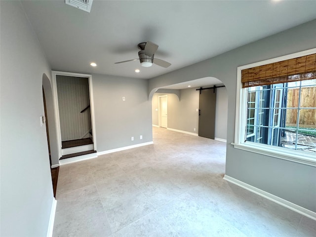 142 Beverly Ln, Bellaire, TX 77401 - spare room with arched walkways, a ceiling fan, a barn door, recessed lighting, and stairs