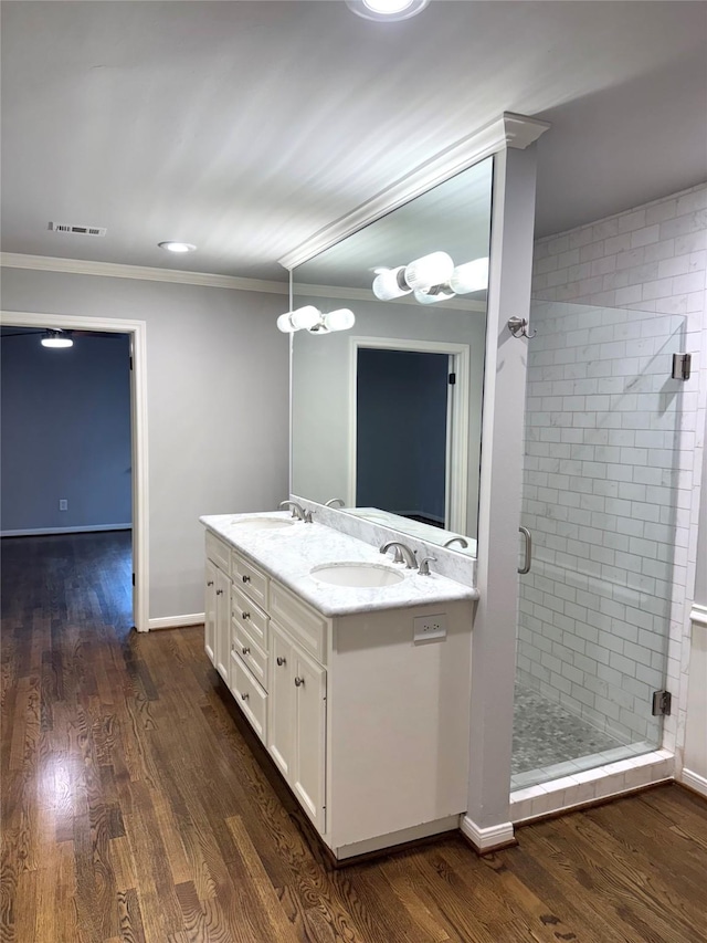 142 Beverly Ln, Bellaire, TX 77401 - bathroom featuring double vanity, a stall shower, crown molding, and wood finished floors