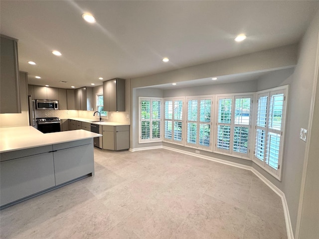 142 Beverly Ln, Bellaire, TX 77401 - kitchen with appliances with stainless steel finishes, gray cabinetry, recessed lighting, light countertops, and decorative backsplash