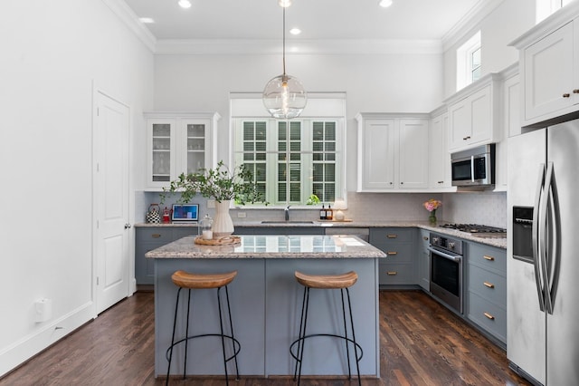 5658 Darling St, Houston, TX 77007 - kitchen featuring appliances with stainless steel finishes, crown molding, backsplash, a breakfast bar, and a kitchen island