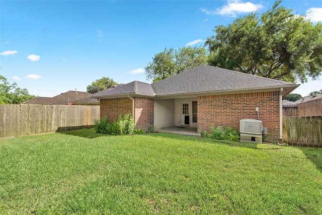 2721 Overland Trl, Dickinson, TX 77539 - rear view of house featuring a fenced backyard, roof with shingles, brick siding, and a patio area