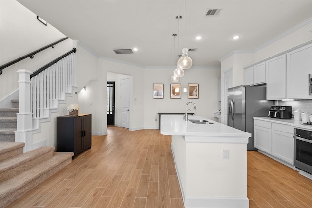 3207 Cedar Dawn Ln, Houston, TX 77091 - kitchen featuring stainless steel appliances, ornamental molding, light wood-style flooring, a kitchen island with sink, and pendant lighting