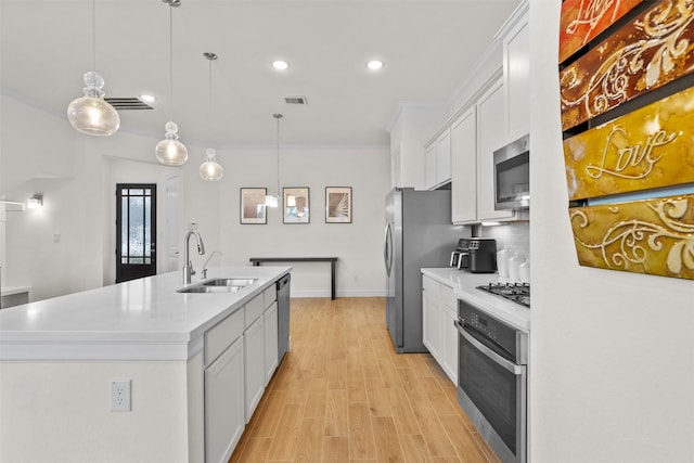 3207 Cedar Dawn Ln, Houston, TX 77091 - kitchen with appliances with stainless steel finishes, ornamental molding, a kitchen island with sink, white cabinetry, and light countertops