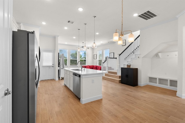 3207 Cedar Dawn Ln, Houston, TX 77091 - kitchen with stainless steel appliances, open floor plan, white cabinetry, a center island with sink, and light countertops