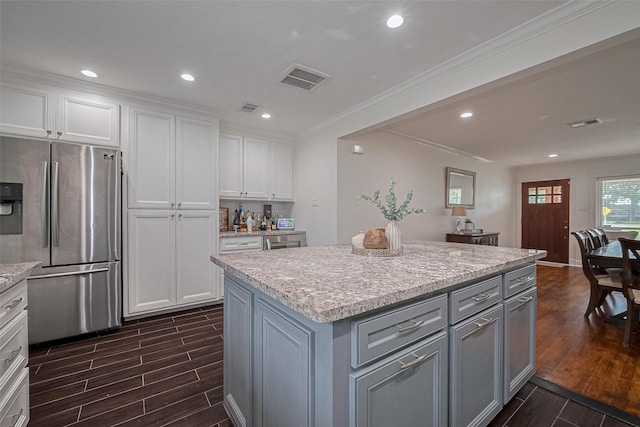 1931 Ansbury Dr, Houston, TX 77018 - kitchen featuring stainless steel fridge, dark wood-style flooring, gray cabinets, white cabinets, and crown molding