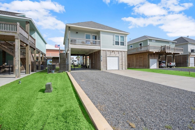 3292 Hidden Gold Prt, Bolivar, TX 77650 - raised beach house featuring driveway, a garage, a front yard, and stairway