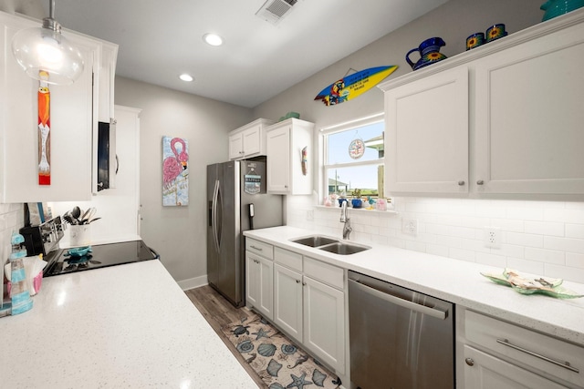 3292 Hidden Gold Prt, Bolivar, TX 77650 - kitchen featuring stainless steel appliances, white cabinetry, recessed lighting, tasteful backsplash, and hanging light fixtures