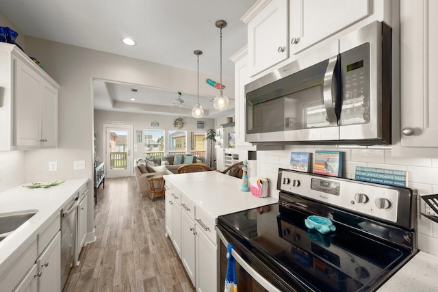 3292 Hidden Gold Prt, Bolivar, TX 77650 - kitchen featuring appliances with stainless steel finishes, light wood finished floors, open floor plan, backsplash, and recessed lighting