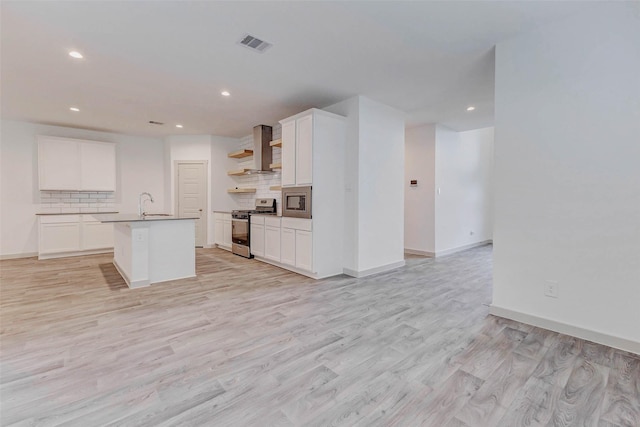 3026 Stock Orchard Ln, Houston, TX 77047 - kitchen with stainless steel appliances, wall chimney range hood, open shelves, backsplash, and light wood-style flooring