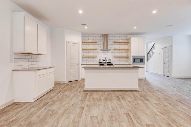 3026 Stock Orchard Ln, Houston, TX 77047 - kitchen with open shelves, wall chimney range hood, stainless steel microwave, backsplash, and white cabinetry