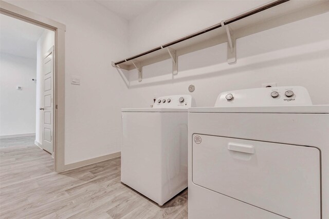 3026 Stock Orchard Ln, Houston, TX 77047 - washroom with washing machine and clothes dryer and light wood-type flooring
